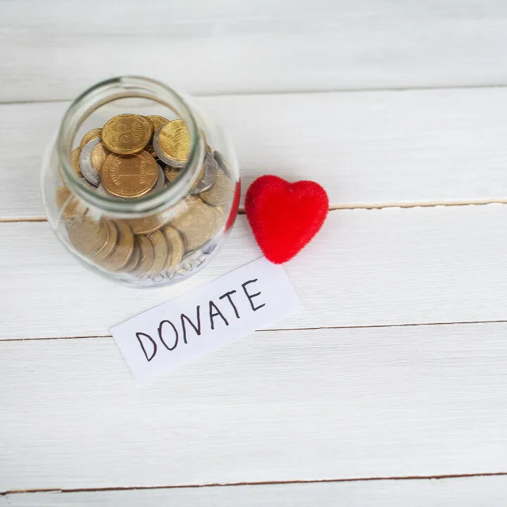 jar of coins with sign that says donate and a heart