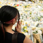 woman praying at tribute for tai po fire victims